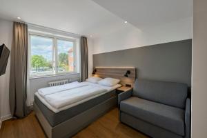 a bedroom with a bed and a chair and a window at Copenhagen Go Hotel in Copenhagen