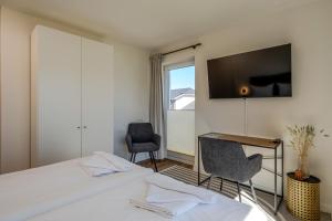 a bedroom with a bed and a desk and a window at Johouse Zingst Johouse Zimmer 07 in Zingst