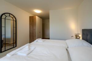 a bedroom with two white beds and a mirror at Johouse Zingst Johouse Zimmer 09 in Zingst