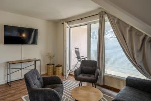 a living room with two chairs and a window at Johouse Zingst Johouse Zimmer 15 in Zingst