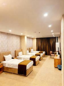 a hotel room with four beds in a row at Ward Hotel Basra in Al Başrah +93 photos