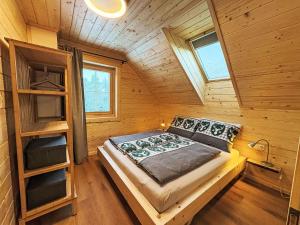 a bedroom with a bed in a wooden cabin at Chalet Nockhütte by Interhome in Hochrindl