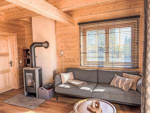 a living room with a couch and a fireplace at Chalet Nockhütte by Interhome in Hochrindl