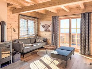 a living room with a couch and a fireplace at Chalet Nockhütte by Interhome in Hochrindl