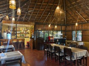 a restaurant with tables and chairs in a room at Hotel Tharu Garden in Sauraha
