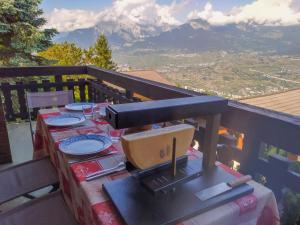 a table on a balcony with a view of a mountain at Chalet Chalet Le Trèfle by Interhome in Salins