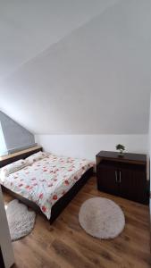 a bedroom with a bed and a dresser and rug at Casa de vacanta Bulz in Bulz