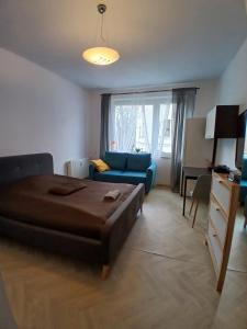 a bedroom with a bed and a blue couch at Pokoje z balkonami & Parking, 300m do Molo in Sopot
