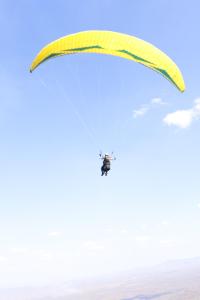 a person riding a parachute in the sky at Sítio do Bosco Park in Tianguá