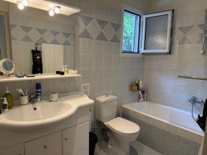 a bathroom with a sink and a toilet and a tub at Villa Rhodos Skiathos in Skiathos +38 photos
