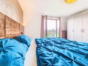 a bedroom with a bed with blue sheets and a window at Apartment Schöser by Interhome in Weerberg +34 photos