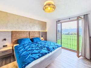 a bedroom with a large bed and a large window at Apartment Schöser by Interhome in Weerberg