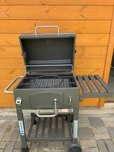 a barbecue grill sitting next to a wooden wall at Apartament Pod Wiśnią in Supraśl