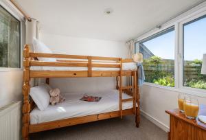 a bedroom with two bunk beds with a teddy bear at Boskenna in Tintagel