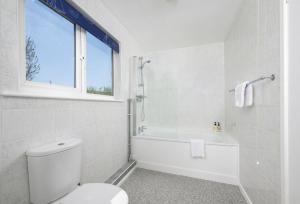 a bathroom with a toilet and a tub and a window at Boskenna in Tintagel +33 photos