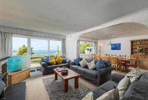 a living room with couches and a large window at Boskenna in Tintagel