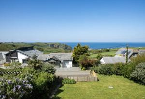a view of a house with the ocean in the background at Boskenna in Tintagel