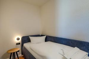 a small room with a bed and a stool at Johouse Zingst Johouse Zimmer 05 in Zingst