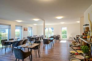 a dining room with tables and chairs and windows at Johouse Zingst Johouse Zimmer 06 in Zingst