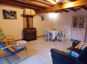 a living room with a table and a stove at Gîte Pyrénées Ariège Ustou in Ustou +8 photos