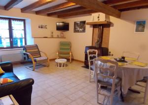 a living room with a table and chairs and a stove at Gîte Pyrénées Ariège Ustou in Ustou