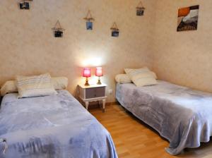 two beds in a room with two lamps on a night stand at Gîte Pyrénées Ariège Ustou in Ustou