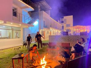 a group of people sitting around a fire in a yard at MAR y LAGO EXPERIENCE in Lunahuaná