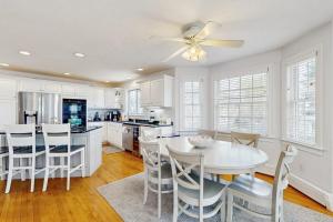a white kitchen with a white table and chairs at York Starfish Haven in York