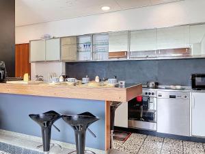 a kitchen with a counter with black stools in it at Villa Villa Bikini by Interhome in Saint-Gingolph