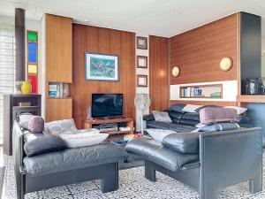 a living room with two leather couches and a television at Villa Villa Bikini by Interhome in Saint-Gingolph
