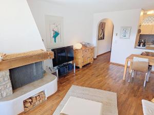 a living room with a fireplace and a table at Apartment Toissa A6 by Interhome in Salouf