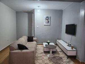 a living room with a couch and a tv at Zariah Homes 1 in Kakamega +23 photos