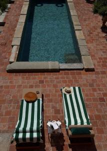 two chaise lounges next to a swimming pool at Relais Conac 1888 - Luxury B&B - Adults Only in Castelnuovo Don Bosco