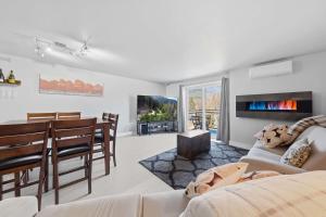 a living room with a couch and a dining room at Modern Condo with Pool - Le Rendez-Vous in Beaupré +50 photos
