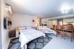 a bedroom with two beds and a dining room at Modern Condo with Pool - Le Rendez-Vous in Beaupré