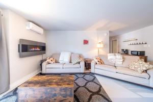 a living room with two couches and a fireplace at Modern Condo with Pool - Le Rendez-Vous in Beaupré