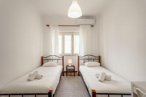 two twin beds in a room with a window at Almada Central by Homing in Almada