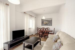 a living room with a couch and a table at Almada Central by Homing in Almada