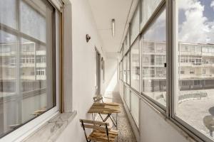 a balcony with windows and a bench in a building at Almada Central by Homing in Almada