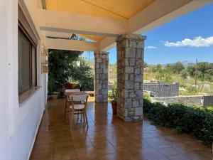 a patio with a table and chairs on a house at Jassemi Studio in Mavrovouni