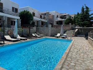 a swimming pool in front of a building at Jassemi Studio in Mavrovouni