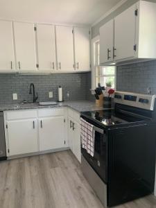 a kitchen with white cabinets and a black stove top oven at Cozy Columbia Retreat in Columbia