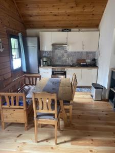 a kitchen with a wooden table and chairs in a room at Ferienhaus 'am Eulennest' in Jabel
