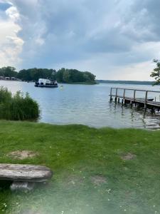 a bench sitting next to a dock on a lake at Ferienhaus 'am Eulennest' in Jabel