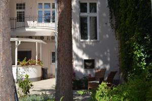 a white house with two chairs and a balcony at Demjén ház in Nyíregyháza