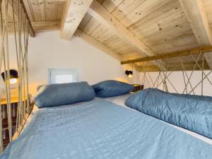 a bed with blue pillows in a room at Tiny Haus 2 - Feige in Kressbronn am Bodensee