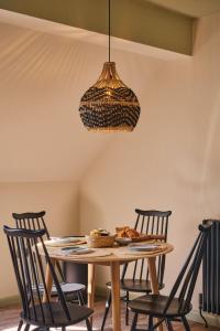 ein Esszimmer mit einem Tisch, Stühlen und einer Lampe in der Unterkunft Grain Loft in Trefeglwys + 18 Fotos