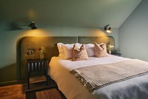 ein Schlafzimmer mit einem großen Bett mit weißen Laken und Kissen in der Unterkunft Grain Loft in Trefeglwys