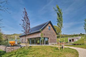 ein Holzhaus mit einem Garten davor in der Unterkunft Grain Loft in Trefeglwys