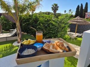a tray of food on a table with a drink at Casa do Barco in Odiáxere